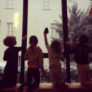 Bimbi osservano la neve dalle finestre dell'asilo