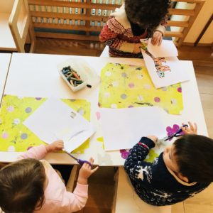 Bimbi ritagliano fogli di carta con le forbici