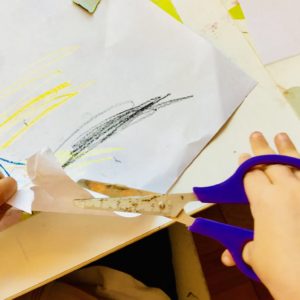 Bimba usa forbici per tagliare un foglio
