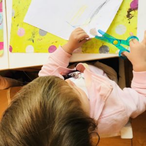 Bimba ritaglia un disegno con le forbici