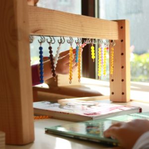 Bimba impegnata in un'attività Montessori per lo sviluppo delle abilità matematiche