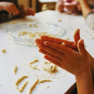 Mani di bimbo che impasta una trofia
