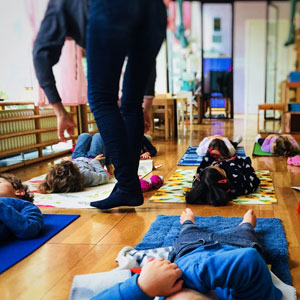 Bimbi fanno yoga sdraiati sui tappetini