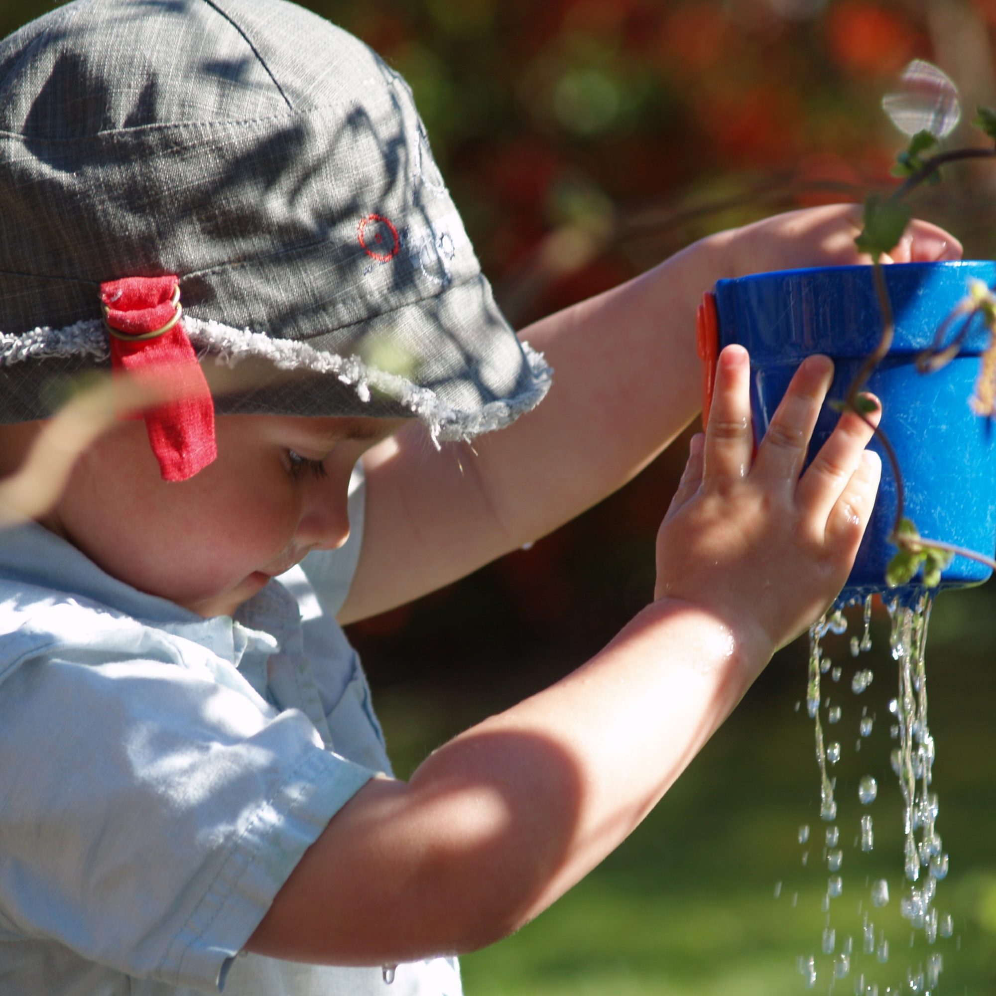 Bambino che gioca con secchiello pieno d'acqua